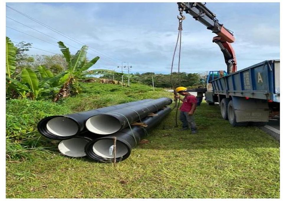 Steel water pipes being unloaded by lorry crane