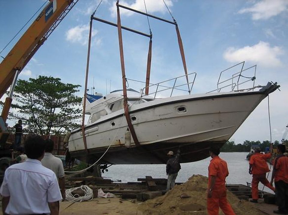 Motor yacht being lifted onto a trailer by crane